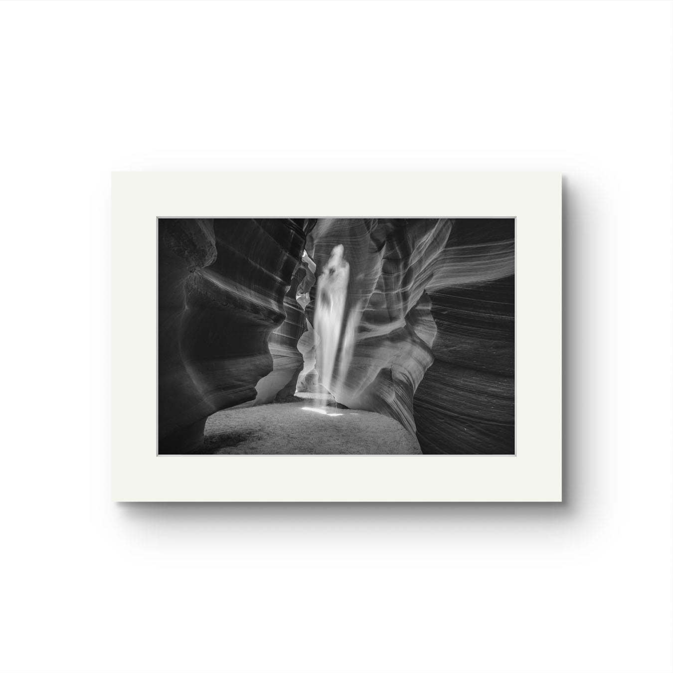 A fine art photography print of a canyon passage with sand threw in the air in a shape of a ghost. Antelope Canyon. Navajo. Page. Arizona