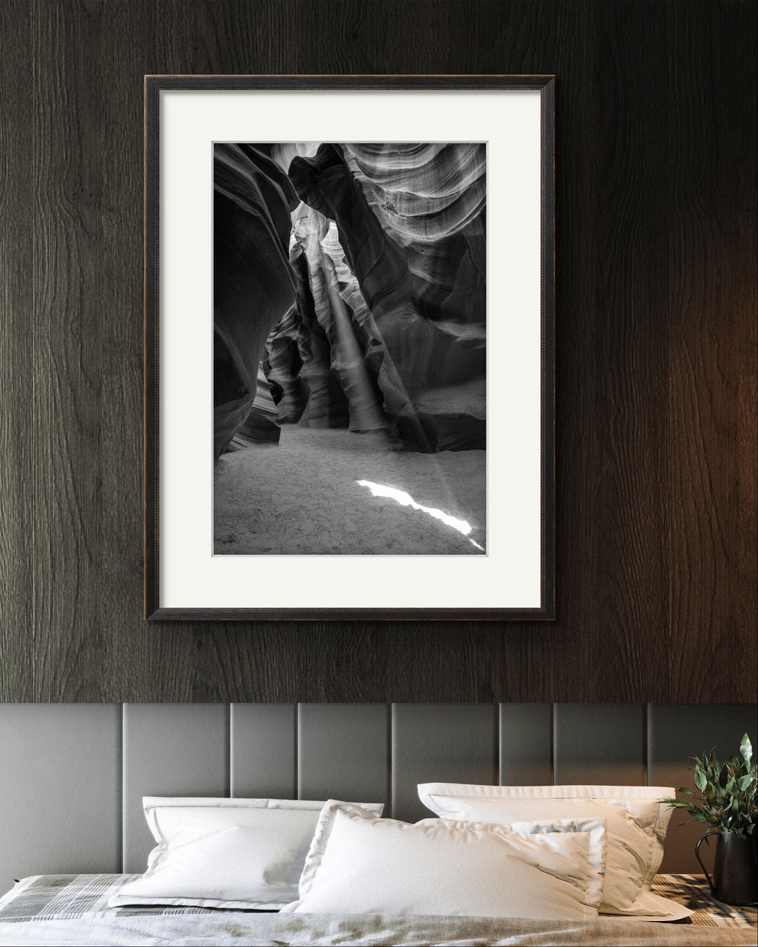 wooden wall in a hotel room. above bed is Framed Fine Art black and white photograph of Canyon’s narrow passageway with the light cascading down the walls like a waterfall of illumination. The intricate patterns of the sandstone, carved by centuries of wind and water, create a mesmerizing texture that draws the eye upward. Antelope Canyon, USA, Arizona