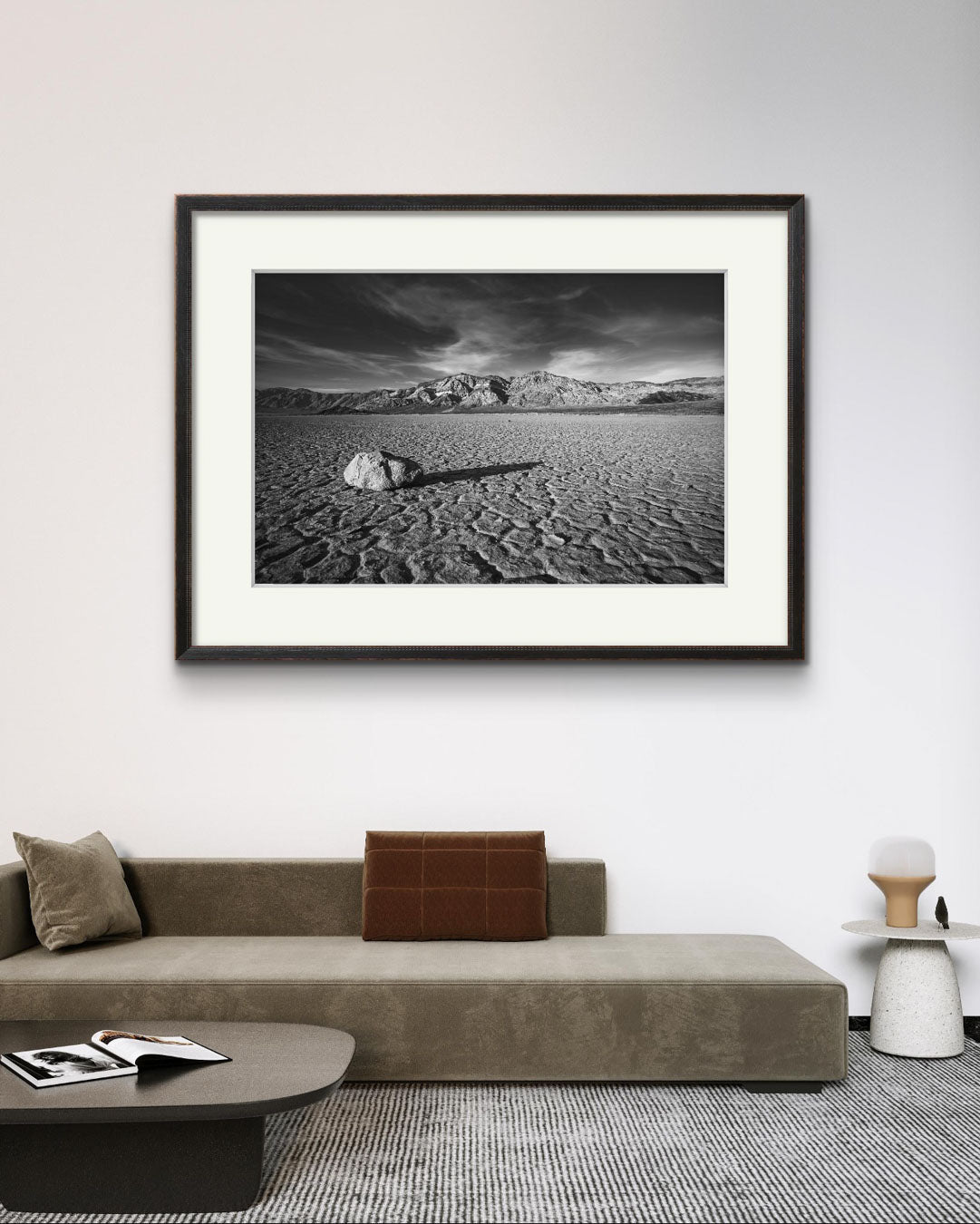 A desert valley in Eastern California. Black and white fine art framed photograph print of a striking desert landscape in Death Valley National Park. Featuring a solitary rock on the cracked, dry lakebed of the Racetrack Playa. For home decor, wall art, or photography enthusiasts, unique nature and landscape prints, this image captures the spirit of the American Southwest.