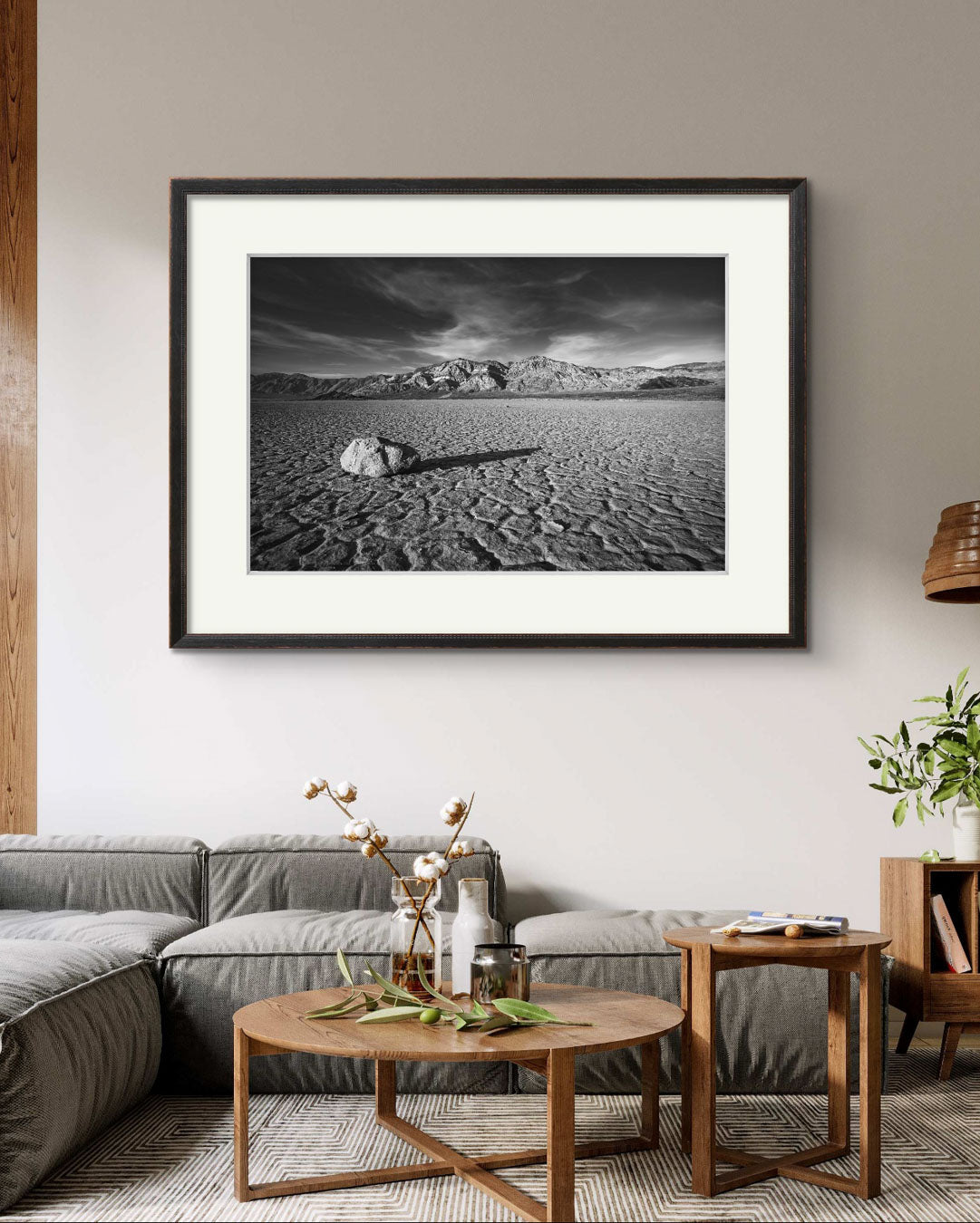 A desert valley in Eastern California. Black and white fine art framed photograph print of a striking desert landscape in Death Valley National Park. Featuring a solitary rock on the cracked, dry lakebed of the Racetrack Playa, mountain ranges in the background. Perfect for home decor, wall art, or photography enthusiasts seeking unique nature and landscape prints of American Southwest.