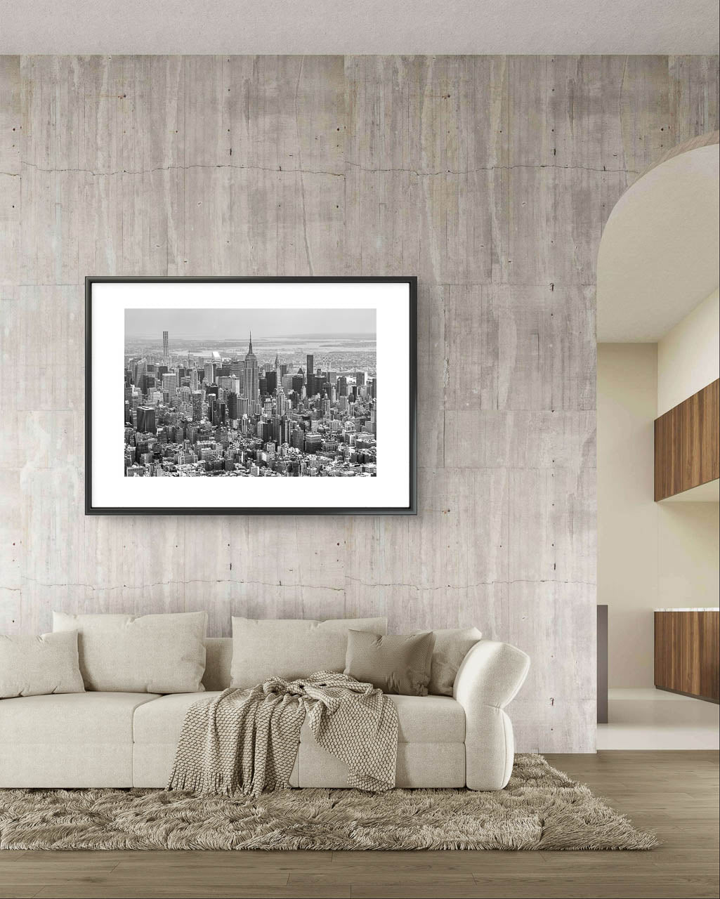 modern living room. concrete wall and on it Framed black and white fine art photography print. Aerial view of Manhattan with the iconic Empire State Building reigning supreme at its center. The photograph captures the city in all its grandeur, with skyscrapers reaching for the sky and the bustling streets below. NYC. New York City
