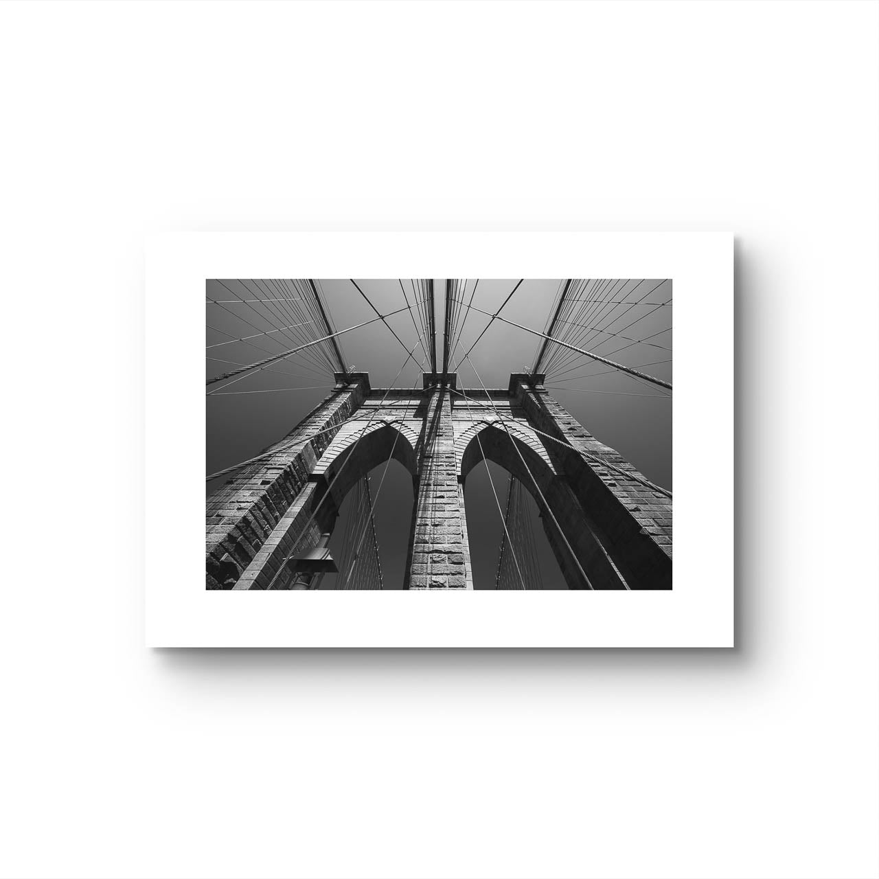 Print of Brooklyn Bridge, fine art black and white print. Shot from the perspective of a pedestrian looking up, the image highlights the intricate Neogothic arches of one of the bridge's towers. Fine art photography print. Limited Edition, NYC, New York City, USA