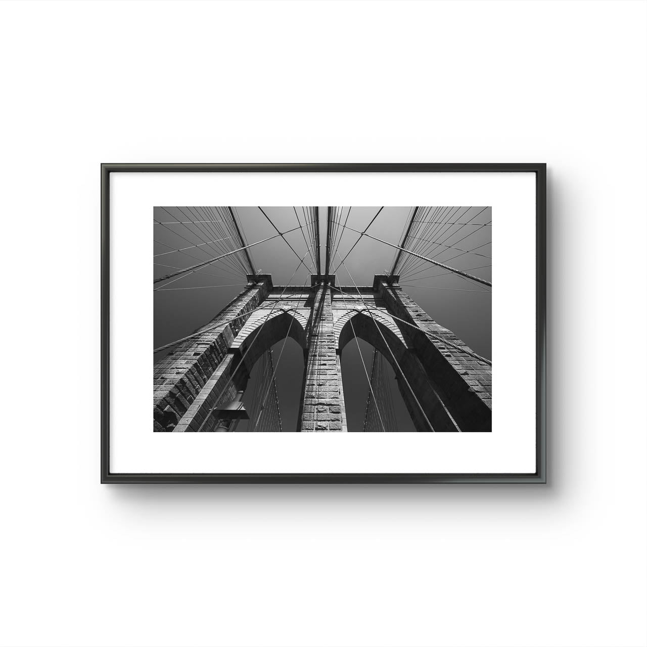 Brooklyn Bridge, fine art black and white print. Shot from the perspective of a pedestrian looking up, the image highlights the intricate Neogothic arches of one of the bridge's towers. Fine art photography print. Limited Edition, NYC, New York City, USA