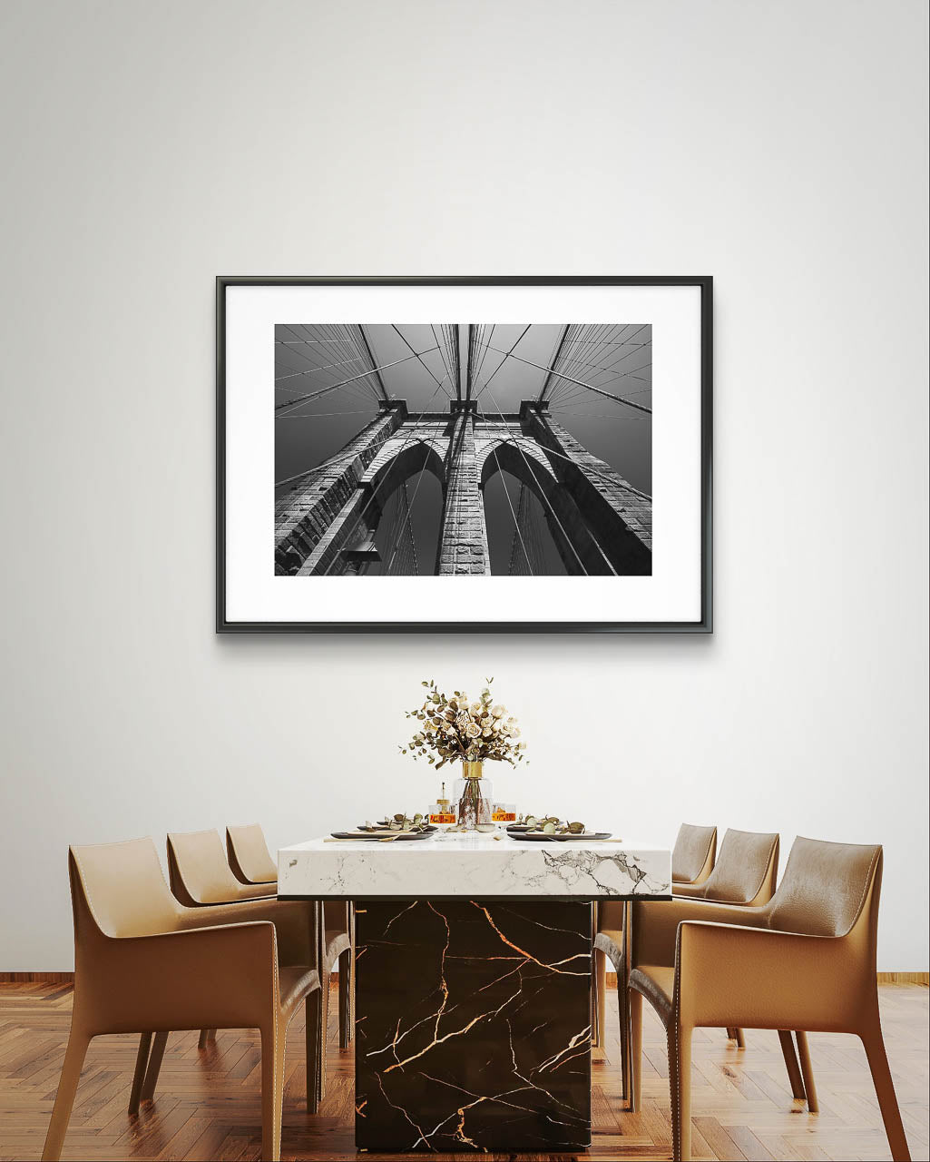 large dinner table . very elegance settings. on the wall is a photograph showcasing Brooklyn Bridge, fine art black and white print. Shot from the perspective of a pedestrian looking up, the image highlights the intricate Neogothic arches of one of the bridge's towers. Fine art photography print. Limited Edition, NYC, New York City, USA