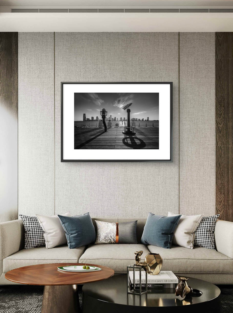 Modern home living room with large comfy sofa and cushions on top, Over it Black-and-white fine art photography print of a city skyline viewed from a waterfront deck, featuring telescopes and railings casting long shadows under a dynamic sky. Limited Edition, Pier 25 , New York City, NYC. USA