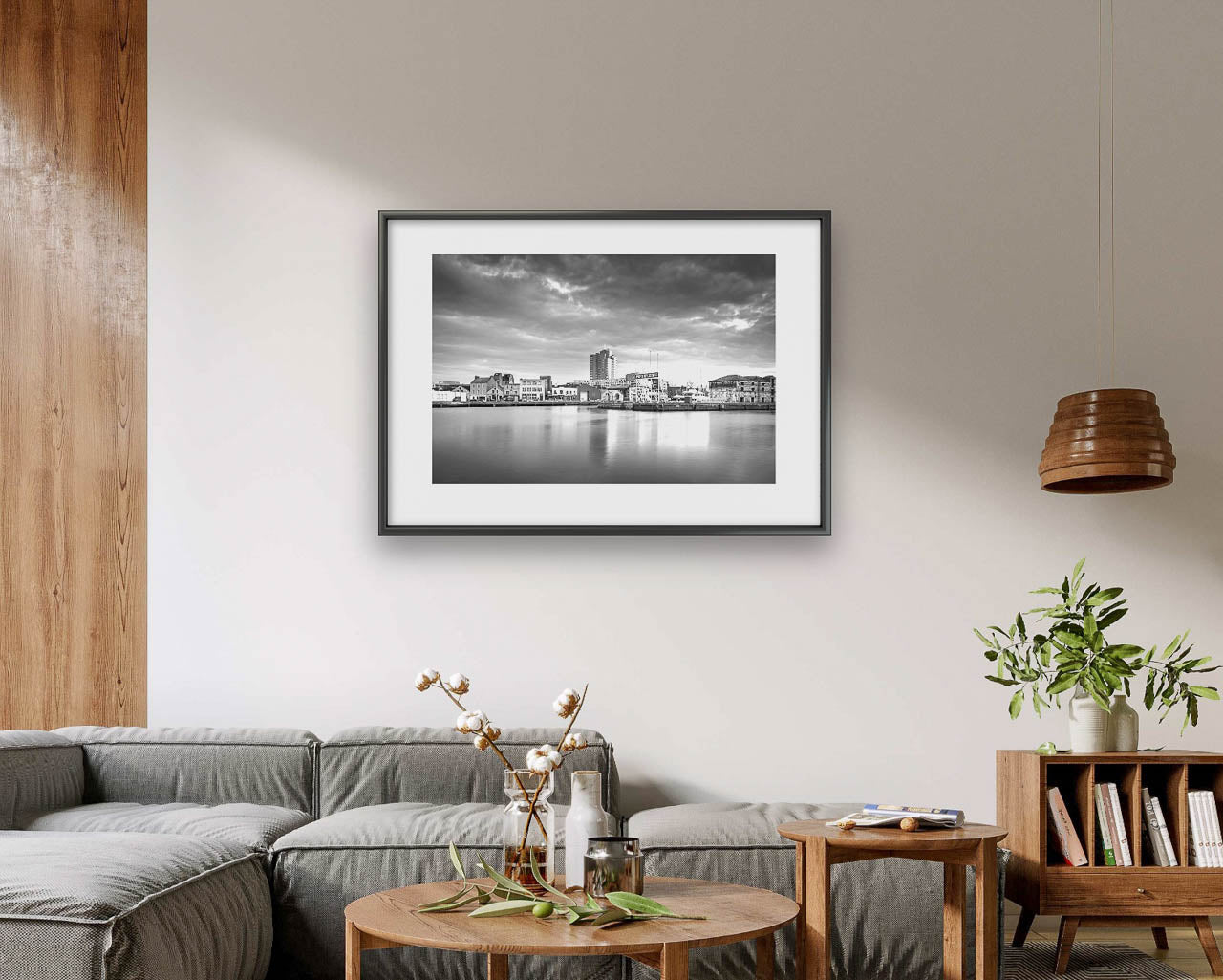 Living room in modern home, Black and white framed Fine Art photograph of a calm waterfront scene with industrial buildings in the focal point. The long exposure effect creates smooth water reflections. streaked clouds in the sky, enhancing the tranquil, moody atmosphere of the port area .Albert Quay & Victoria Rd.  Limited Edition Print, Fine Art photography. Cork City, Ireland