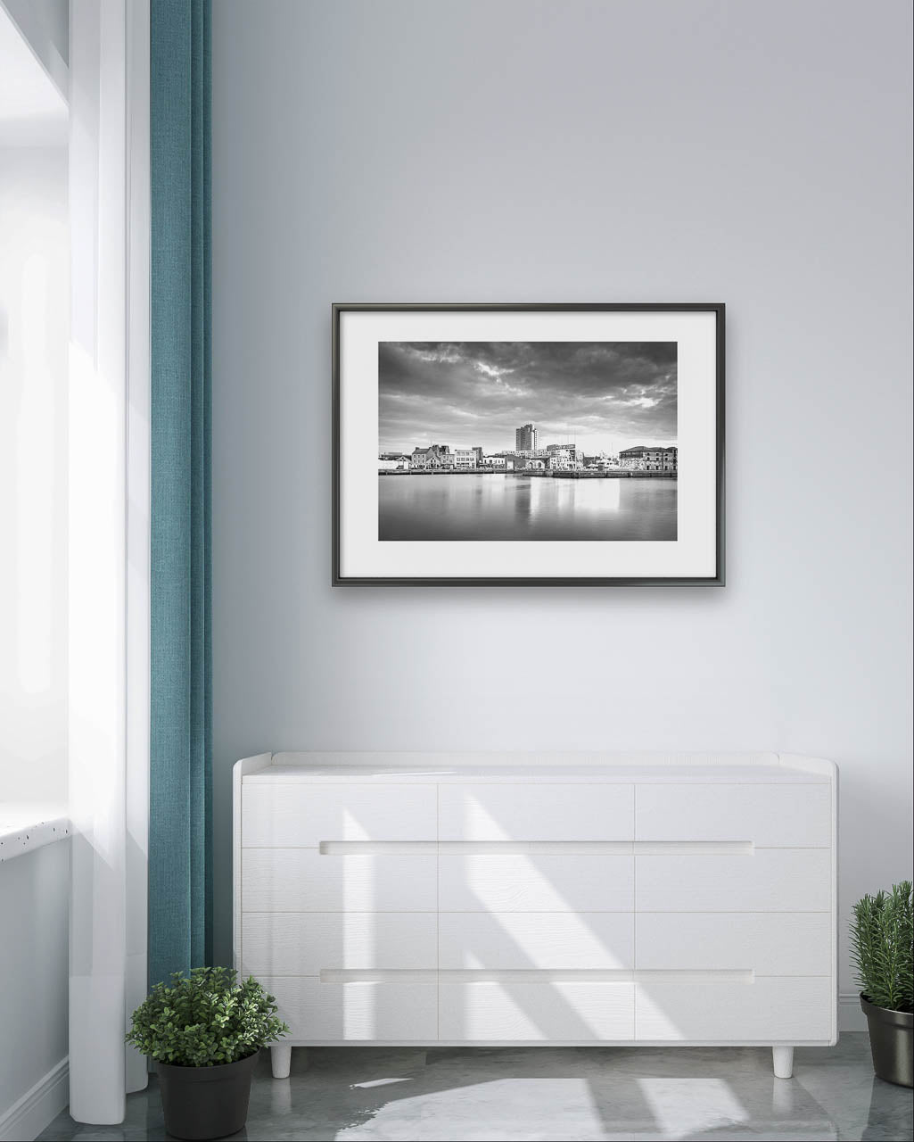 White 4 chest of drawers, few plants on the floor, Black and white framed Fine Art photograph of a calm waterfront scene with industrial buildings in the focal point. The long exposure effect creates smooth water reflections. streaked clouds in the sky, enhancing the tranquil, moody atmosphere of the port area .Albert Quay & Victoria Rd.  Limited Edition Print, Fine Art photography, Cork City, Ireland