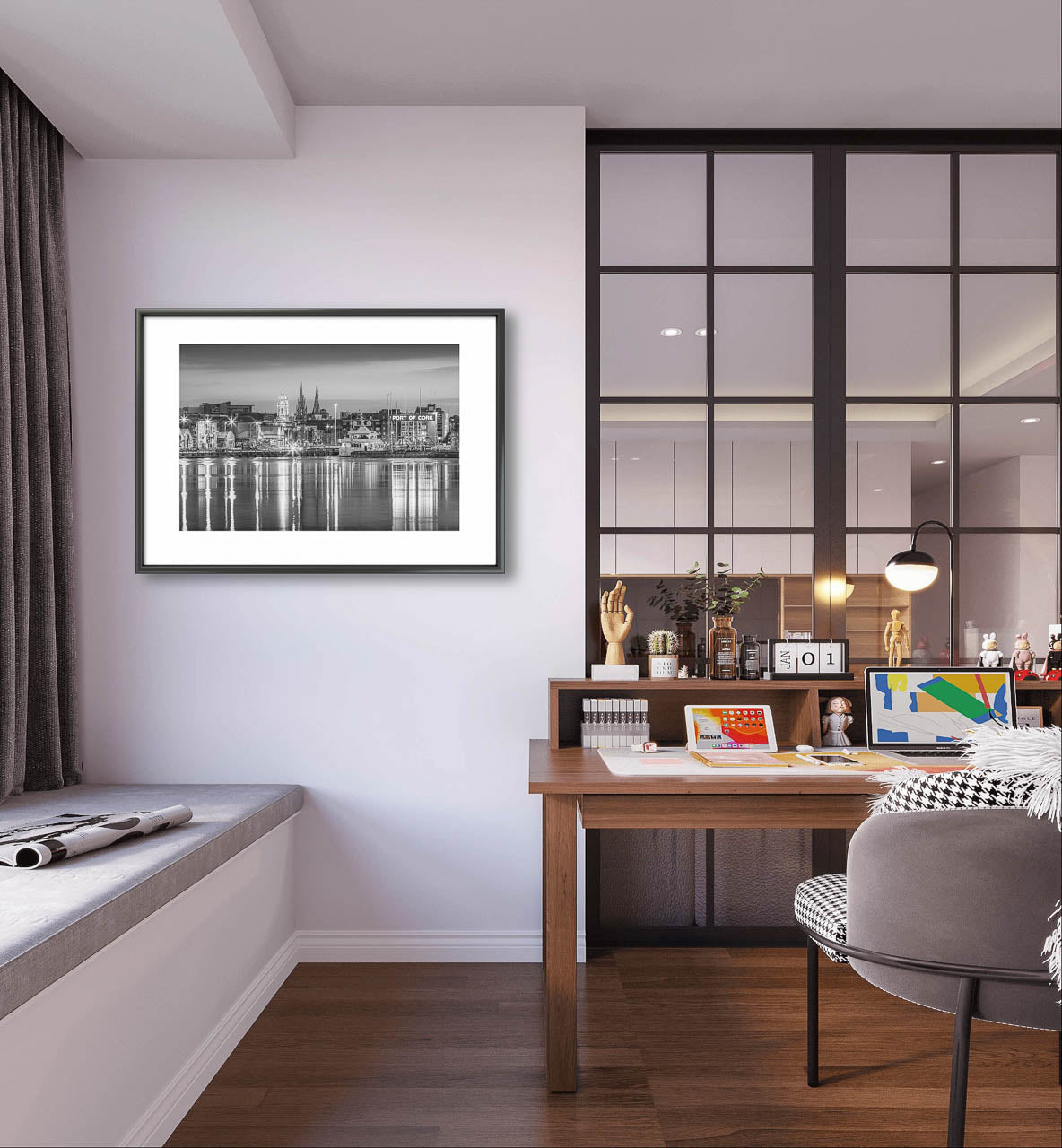 Framed black-and-white fine art photograph of Cork, Ireland, displayed on a minimalist wall. The photo captures a serene waterfront view with reflections of historic buildings and church spires in the water. Artwork is hanged up in the cosy room with an office chair and desk, modern table lamp.  Limited Edition