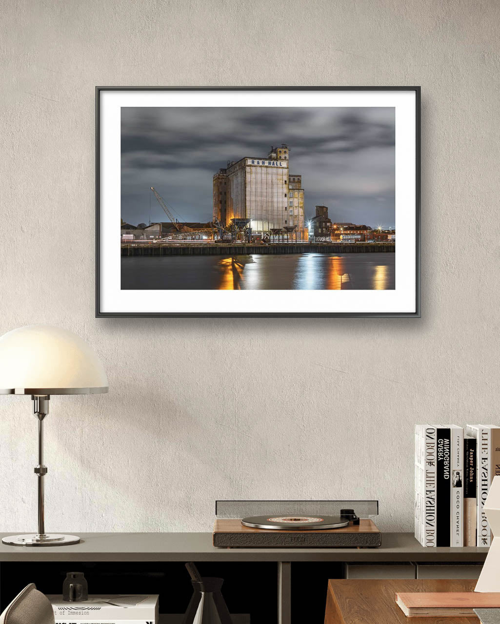RH Hall. Framed fine art photograph of an industrial scene at night, featuring a building labeled 'R&H Hall' with surrounding structures and cranes. The long exposure captures smooth water reflections of lights from the building, creating a calm, reflective atmosphere under a cloudy sky. Cork City, Ireland. Limited Edition Print
