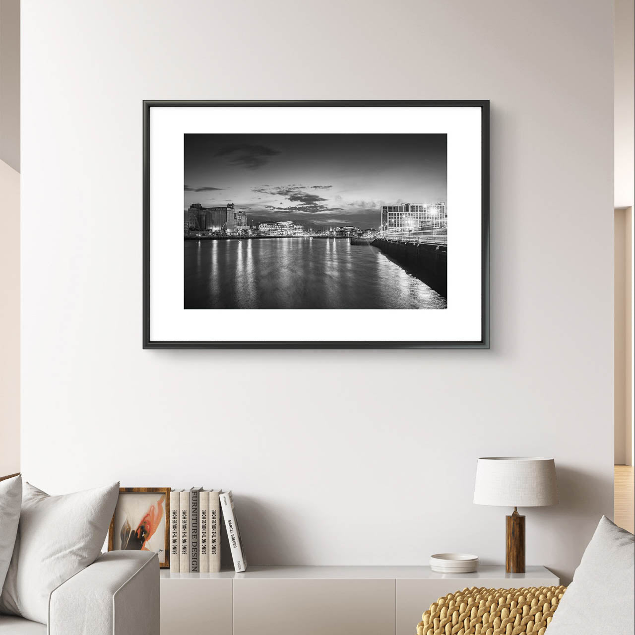 White Wall , Framed Black and white photograph of a riverside cityscape at dusk. The calm river reflects lights from buildings along the shoreline, creating a shimmering effect on the water. Modern buildings line both sides of the river, with a cloudy sky adding a serene, moody atmosphere. The city lights contrast with the darkening sky, giving the scene a peaceful, contemplative quality. Horgan's Quay, Kennedy's Quay, River Lee, Cork City, Ireland. Limited Edition Fine Art Print, Cork City, Ireland