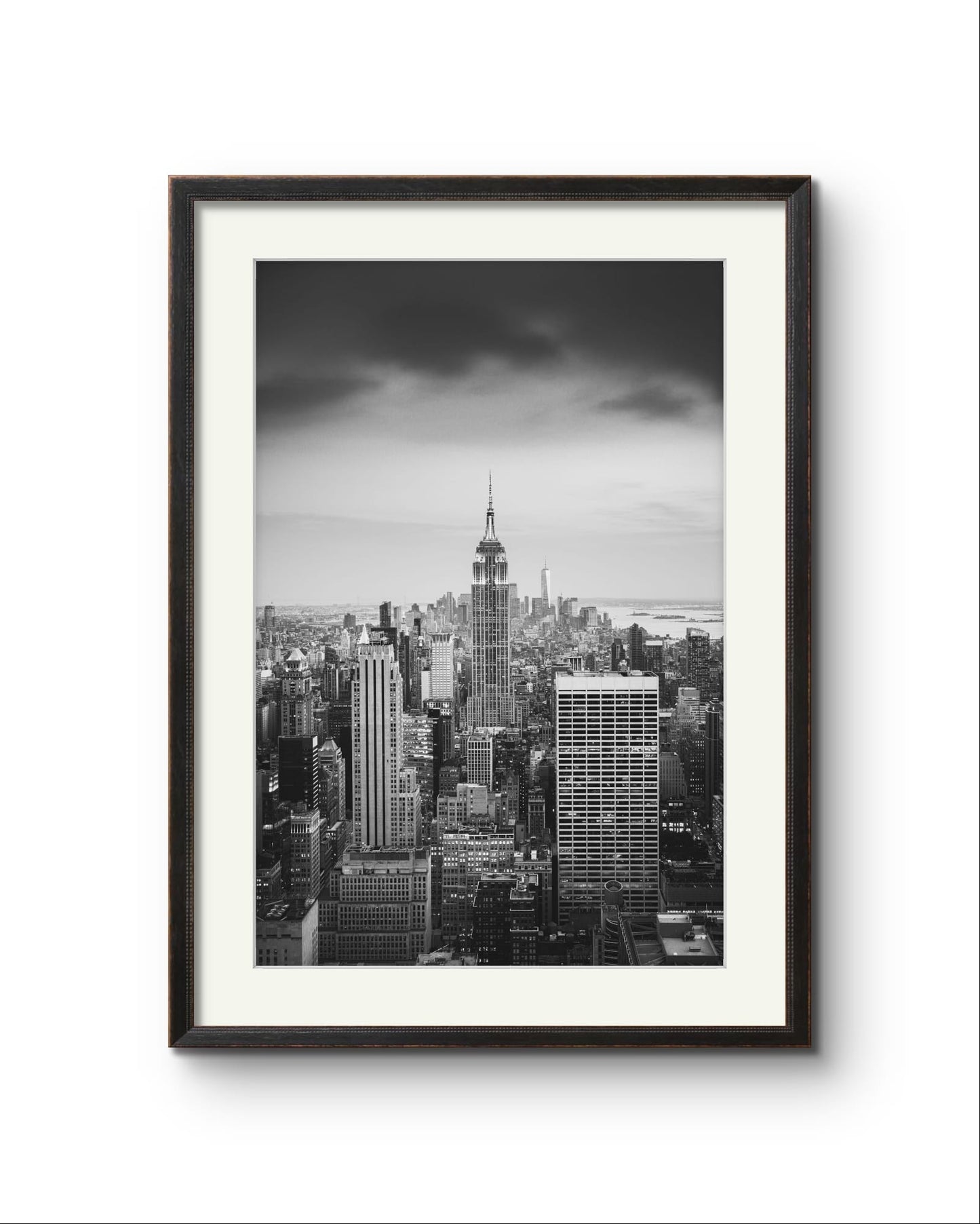 Black and white photography print. A breathtaking view of Manhattan from the terrace of the Rockefeller Centre, looking southward, with the majestic Empire State Building commanding the scene as the focal point. New York City.