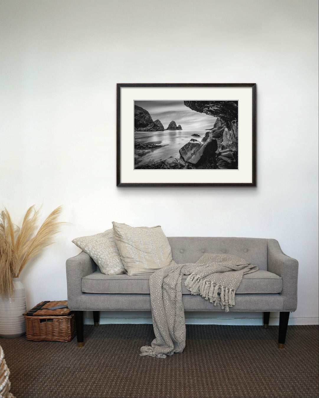 Nice grey sofa with a white wall and Print of a Irish coastal landscape. Wild Atlantic Way. Cork Ireland.  Nohoval Cove