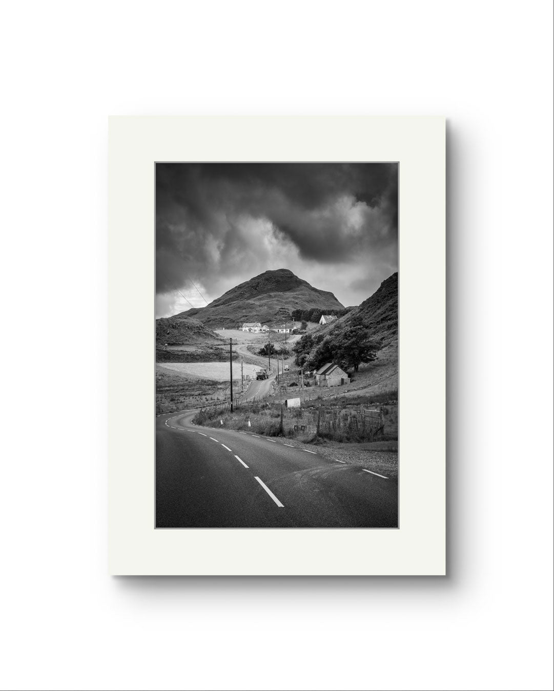 Unfamed black and white fine art photography print showcasing Irish landscape. The twisting road and houses create a magical scenery. Ireland. Co. Donegal. Teelin