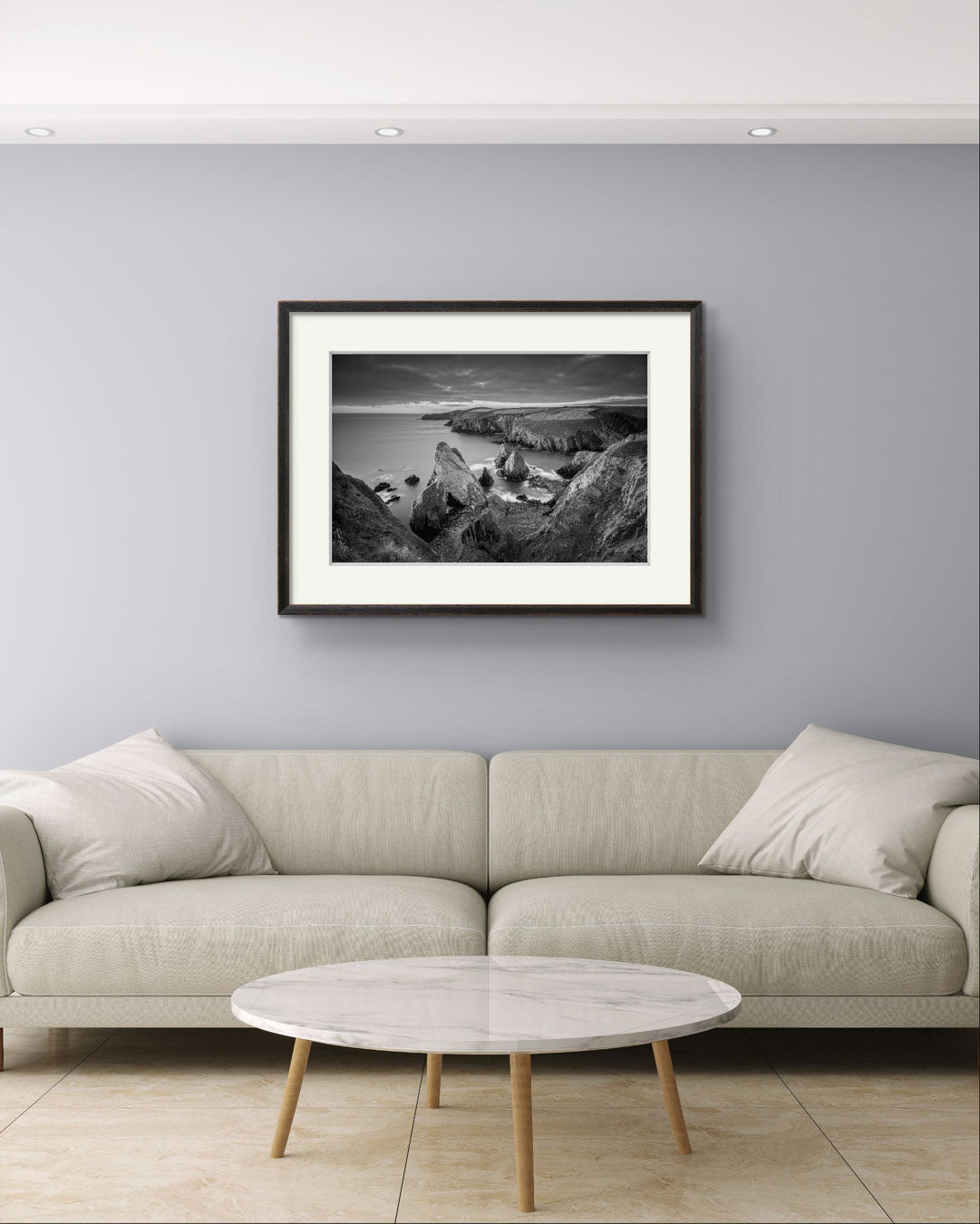 Nice comfy beige sofa and over it Framed black and white photograph of coastal landscape. Cork Ireland