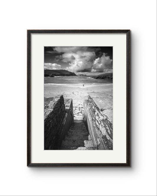 Framed photograph of an Irish Coast, dynamic composition draws your eyes to an ocean and a person walking on the distance beach. Clogher Beach. Dingle Town. Slea Head Drive in County Kerry.