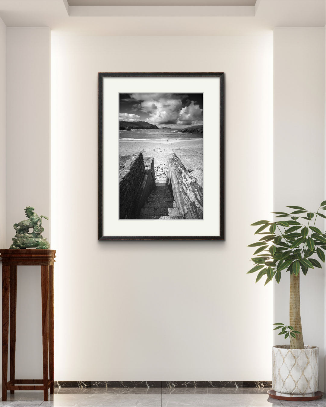 a modern hall and hung up a framed photograph of an Irish Coast, dynamic composition draws your eyes to an ocean and a person walking on the distance beach. Clogher Beach. Dingle Town. Slea Head Drive in County Kerry.