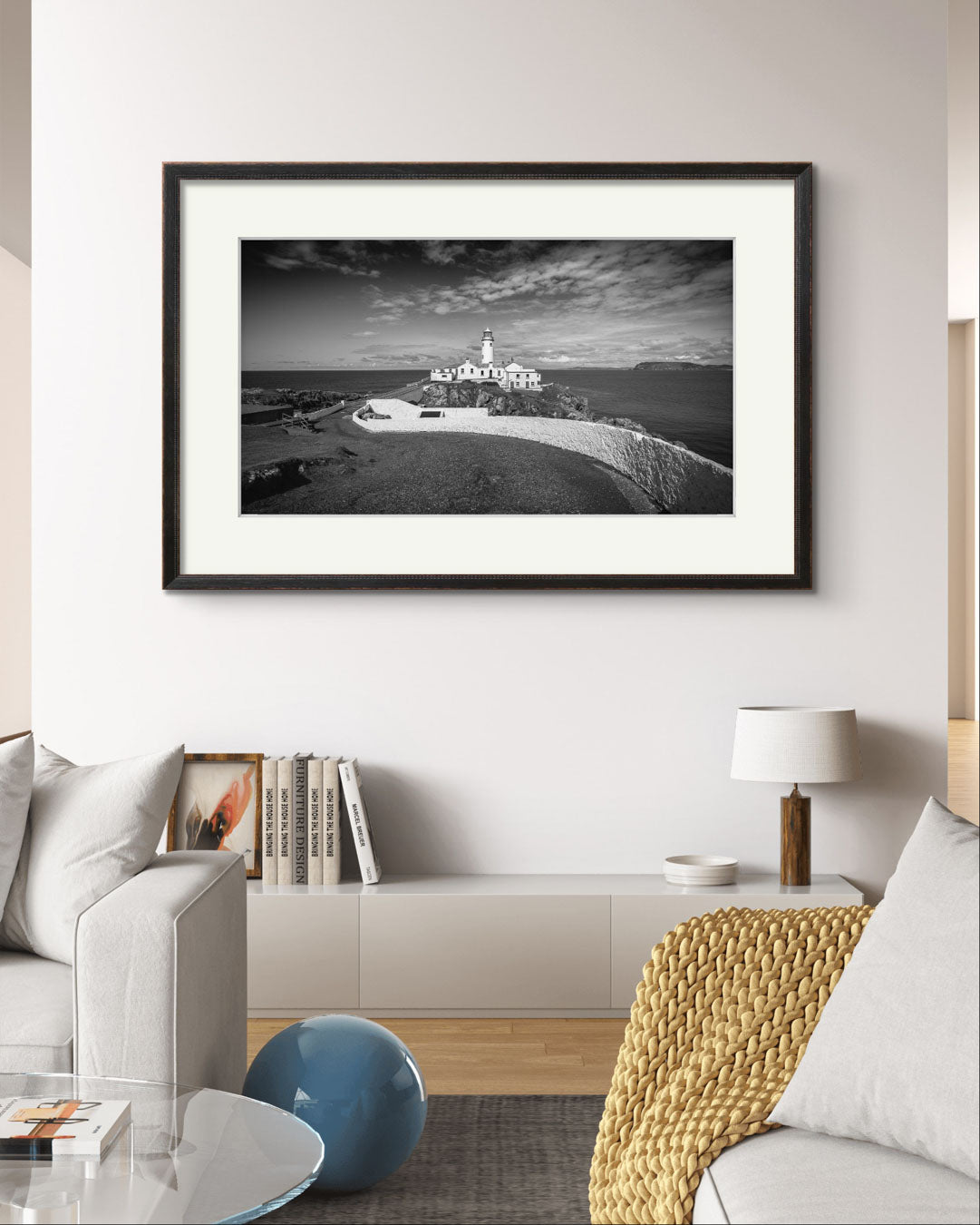 Black and white framed photograph of Irish coastal landscape with a lighthouse in a focal point on the wall i the living room in a modern home. Fanad Head. Donegal. Wild Atlantic Way.