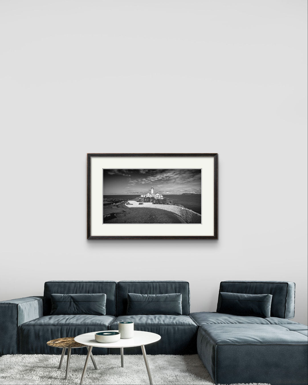 a modern room in a home with hung up a a framed photograph of Irish coastal landscape with a lighthouse in a focal point. Fanad Head. Donegal. Wild Atlantic Way.