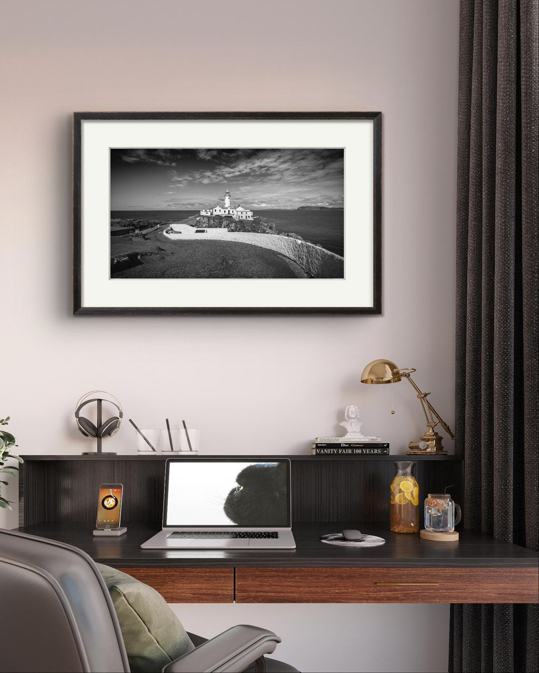 An ofifce with a desk and chair an above it is a framed photograph of Irish coastal landscape with a lighthouse in a focal point. Fanad Head. Donegal. Wild Atlantic Way.