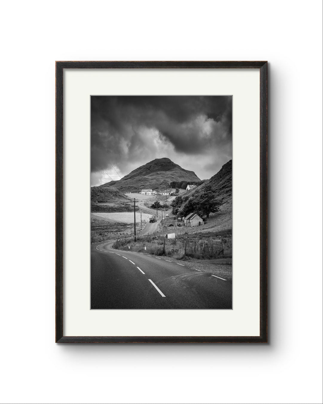 Framed black and white fine art photography print showcasing Irish landscape. The twisting roadnd houses create a magical scenery. Ireland. Co. Donegal. Teelin