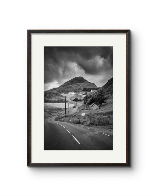 Framed black and white fine art photography print showcasing Irish landscape. The twisting roadnd houses create a magical scenery. Ireland. Co. Donegal. Teelin