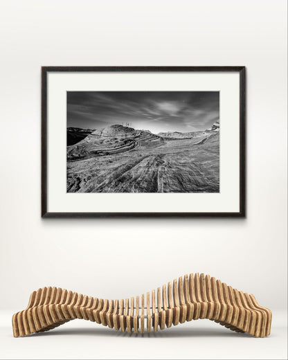 a wavy bench and a larhe piece of home decor on the wall. fine art photography print. in black and white. A print of southern Nevada's Valley of Fire.  Mojave Desert made of red Aztec sandstone. USA