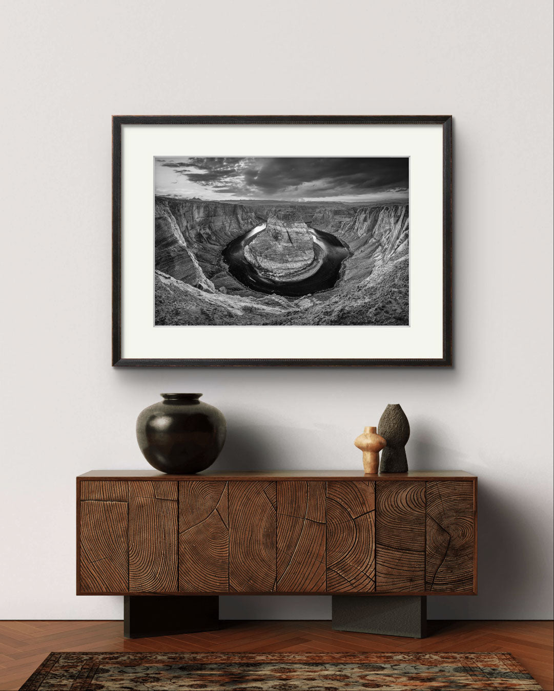 A modern console table, home decor piece on the wall. Black and white fine art photography print of a horseshoe-shaped incised meander of the Colorado River, Page, Arizona. USA