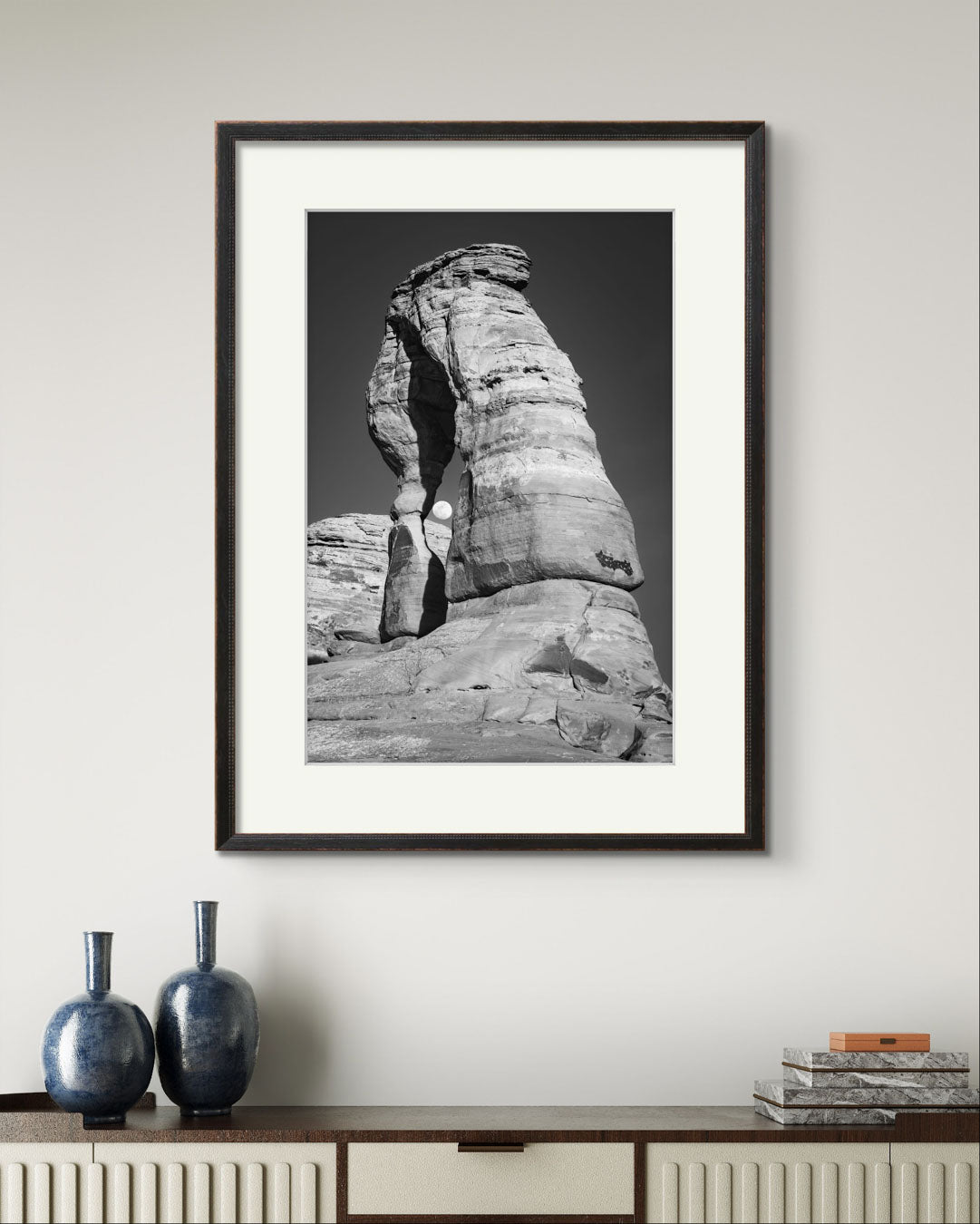 Console table with 2 blue vases and Framed Fine Art black and white photograph of impressive large arch 
 and visible moon through it. Delicate Arch, Moab, USA, Arches National Park