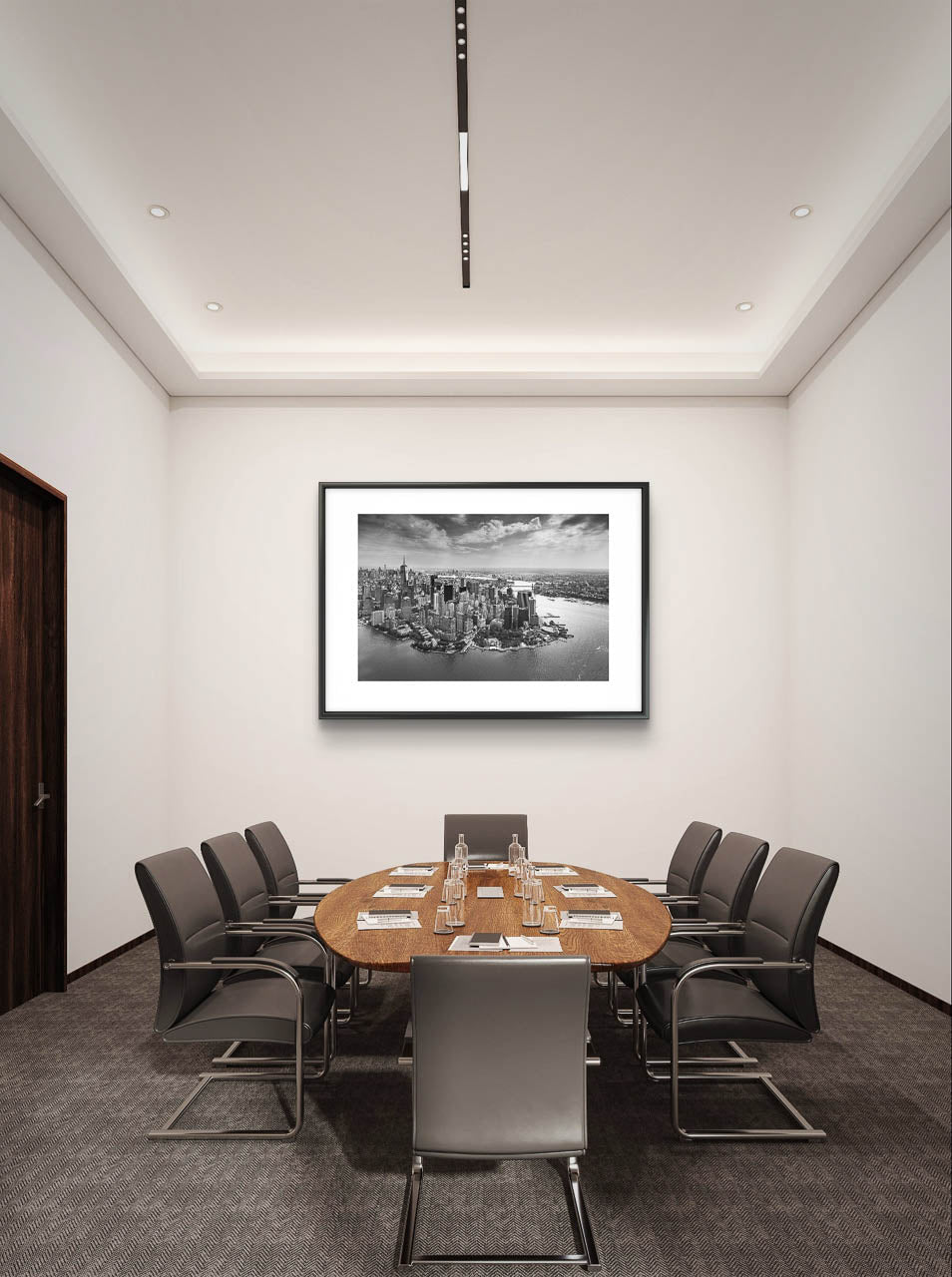 a meeting room with large table and chairs. on the back wall is Framed black and white fine art photography Print. Aerial view of Manhattan. Financial District and towering skyscrapers of Wall Street. New York City.