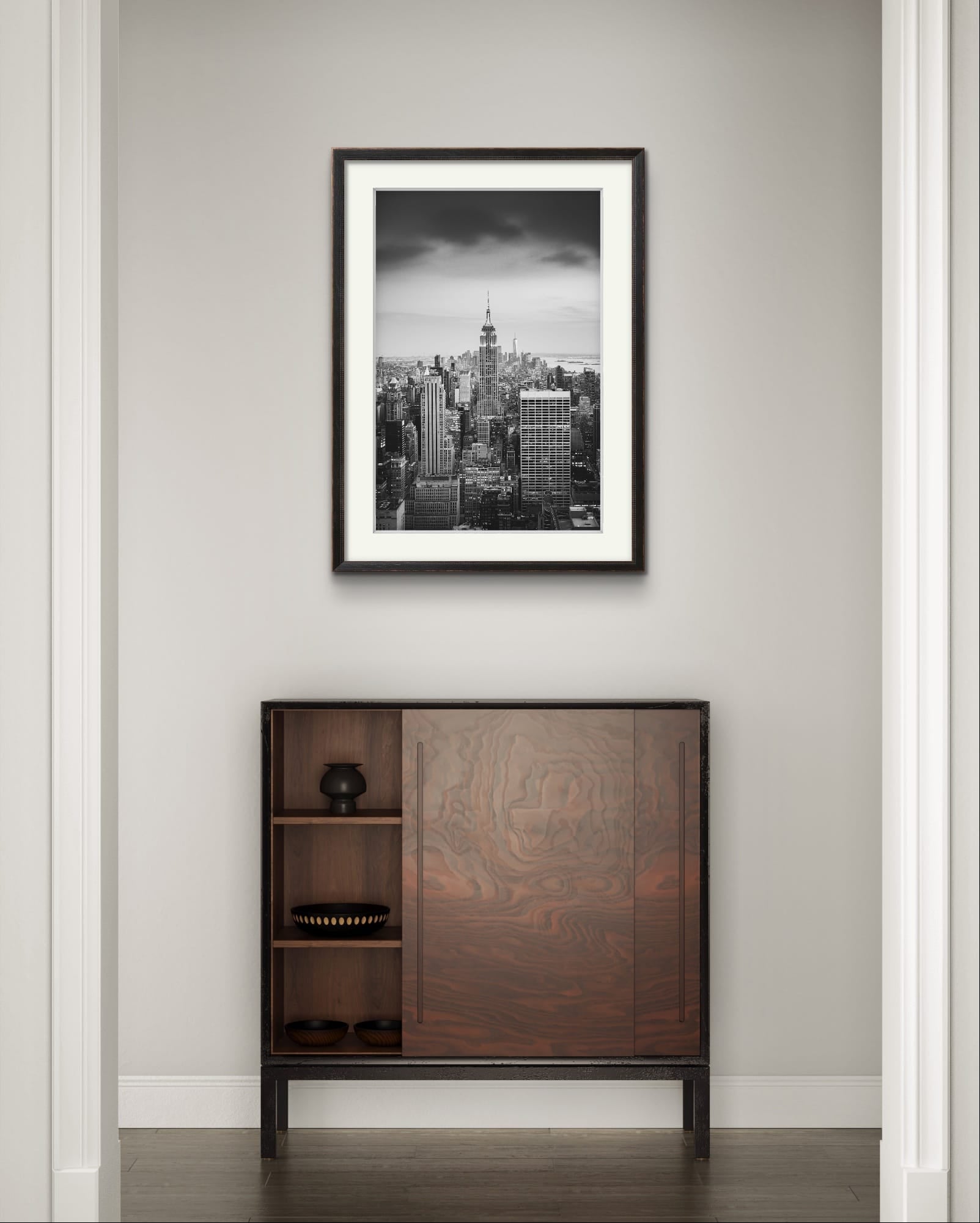 A narrow wall with  displayed Black and white photography print. A breathtaking view of Manhattan from the terrace of the Rockefeller Centre, looking southward, with the majestic Empire State Building commanding the scene as the focal point. New York City.