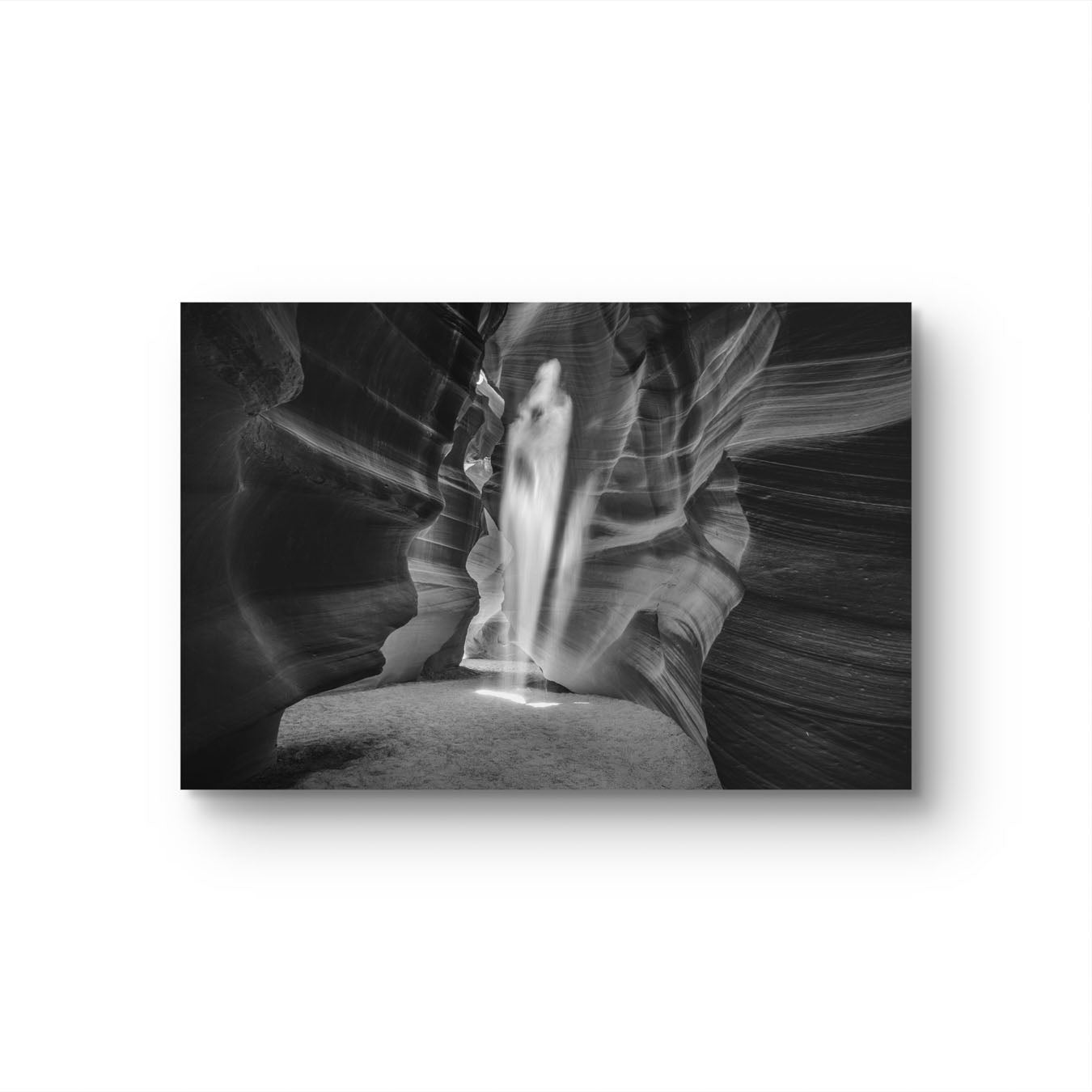 A black and white photography Print of a canyon passage with sand threw in the air  in a shape of a ghost. Antelope Canyon. Navajo. Page. Arizona